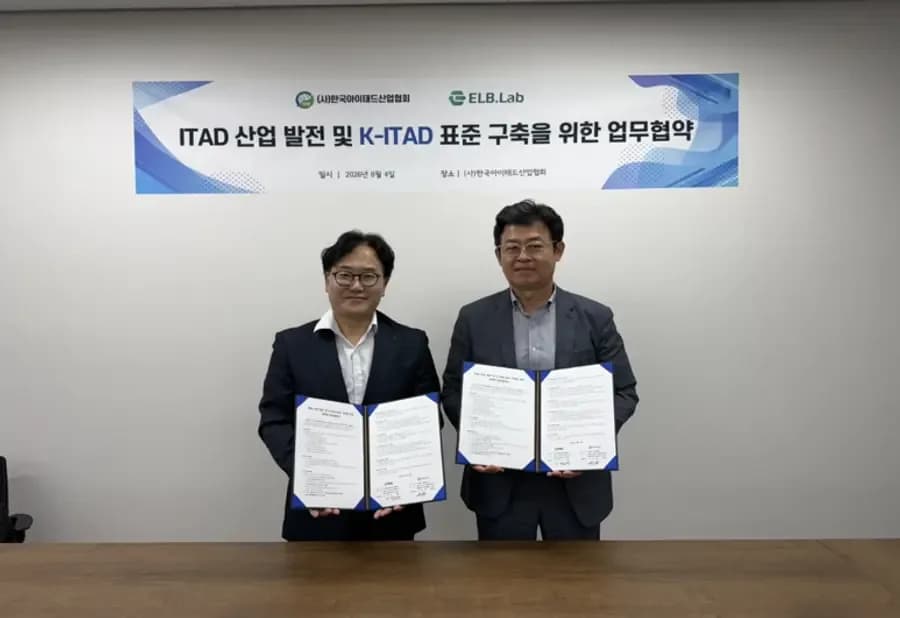 ITAD 산업 발전 및 K-ITAD 표준 구축을 위한 업무협약 현수막 앞에서 협약서를 든 우희택 (주)이엘비랩 대표(왼쪽)와 송효택 (사)한국아이태드산업협회 상근부회장